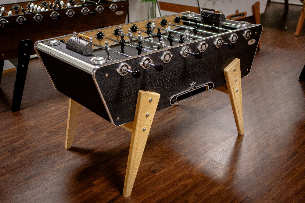 Full view of the Stella Champion Carbon foosball table showcasing its elegant wooden structure with burnt wood effect finish
